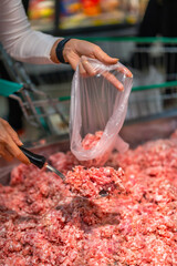 customer hand choosing minced meat(pork) in supermarket