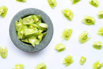 Moringa oleifera seeds in stone mortar on white