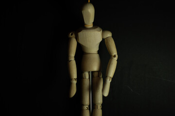 wooden mannequin hang man on black background