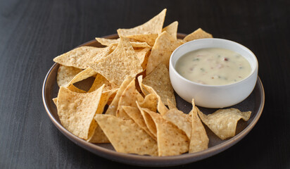 mexican hot queso blanco cheese dip with corn tortilla chips on plate
