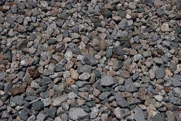 High angle close-up view of a section of gravel stones of a bed for railroad tracks