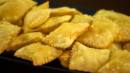 Porção de mini pasteis fritos com molhos