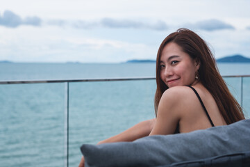 A beautiful young asian woman with the sea and blue sky view