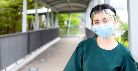 Fototapeta na wymiar Covid-19 Concept and Air Pollution Asian women wear masks and face shield to protect the mouth and nose from the spread of the virus. Take pictures of people focusing on the face and eyes.