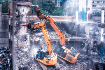 Excavator and cuter demolishing an old building at construction site 