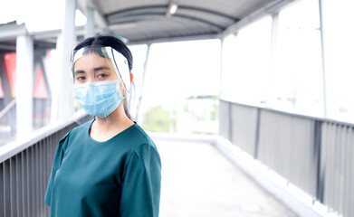 Fototapeta na wymiar Covid-19 Concept and Air Pollution Asian women wear masks and face shield to protect the mouth and nose from spreading the virus. Take pictures people.