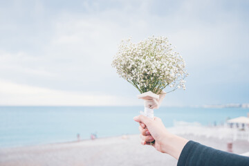 Girl Hand Holding Flower Bouquet by the beach