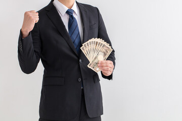 スーツを着た男性が10万円持っている　給付金　援助　コロナ　man money business