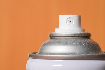 White head spray paint can and brown background with copy space close-up.