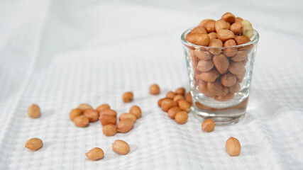 ์Raw nuts overflowing in a glass cup