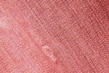 Old jeans texture close up, top view. Denim background, red color toned