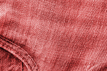 Old jeans texture close up, top view. Denim background, red color toned