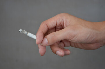 The hand holding a cigarette , close up hand. 