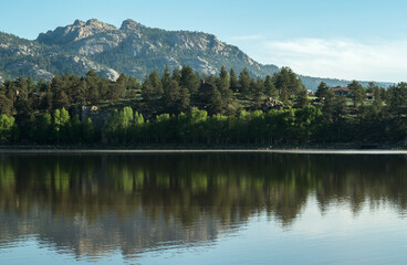 Fototapeta na wymiar Reflective lake with trees and mountain