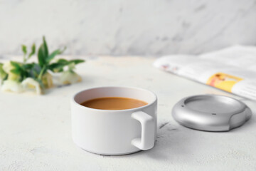 Cup of coffee with heater on white background