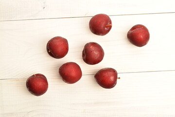 Fototapeta na wymiar Ripe juicy, organic red plum, close-up, on a painted wooden table.