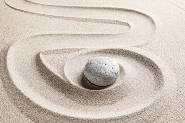 Fototapeta na wymiar Stone on sand with lines. Zen concept