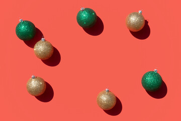 gold and green christmas ornaments pattern on a coral red background