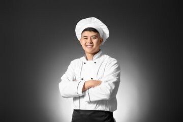 Handsome Asian chef on dark background