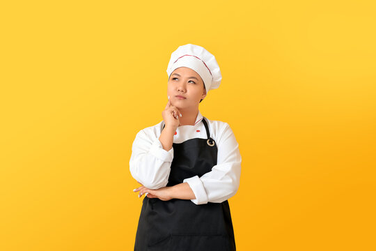 Thoughtful Asian chef on color background