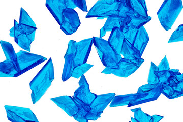Beautiful crystals of Copper Sulphate shown in close-up and isolated against a white background. Copper Sulfate is used in industry, agriculture and medicine and is commonly used in school science. 