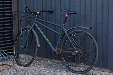 Fototapeta na wymiar Umea, Norrland Sweden - May 10, 2020: black bicycle against dark outdoor wall at Haga