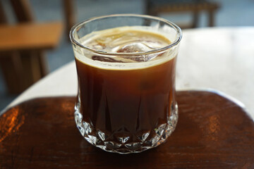 Close up glass of iced black Americano coffee on wooden tray table