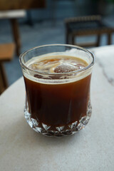 Close up glass of iced black Americano coffee on marbled table