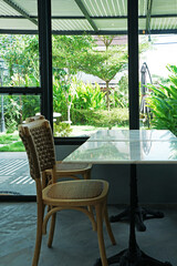 Interior design and decoration of coffee cafe and restaurant decorated with wooden furniture and mirror glass frame with green garden view