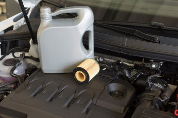 Engine oil and oil filter in the background of the engine compartment of a car