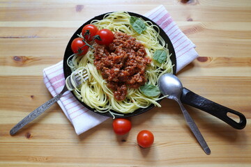 tomato and Basil pasta cooking in a pan gourmet, homemade dish on a wooden table