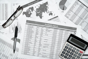 Top view of modern black office desk with notebook, pencil, financial reports and a lot of things....