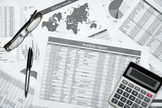 Top view of modern black office desk with notebook, pencil, financial reports and a lot of things. Flat lay table layout.