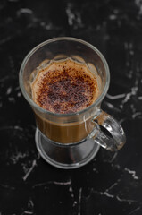 cup of latte on black background with notepad