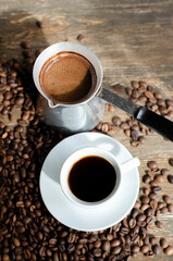 a cup of coffee with sprinkled coffee beans on the table