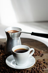 a cup of coffee with sprinkled coffee beans on the table
