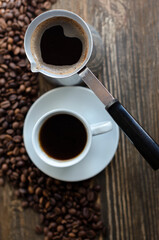 a cup of coffee with sprinkled coffee beans on the table