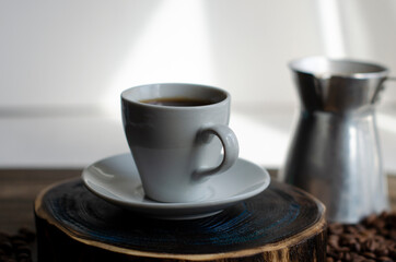 a cup of coffee with sprinkled coffee beans on the table