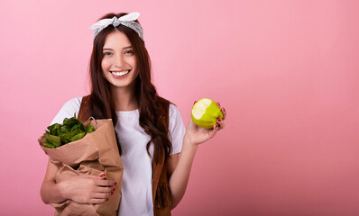 Caucasian girl with plant food in her hands and eats a vitamin apple