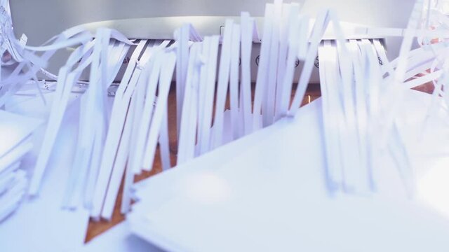 Document shredder with paper shreds on floor.for recycling.