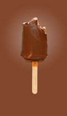 fresh chocolate outer popsicle with some bites on brown background