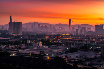 Golden sunrise Kuala Lumpur city skyline view with orange sky, Malaysia