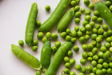 Green fresh peas ans pea pods isolated on white top view.