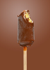 fresh chocolate outer popsicle with some bites on brown background