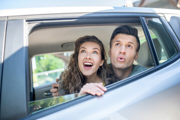 Man and woman looking out of a car window