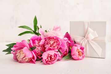 Beautiful peony flowers and gift on table