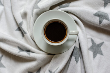 morning cup of coffee on white blanket