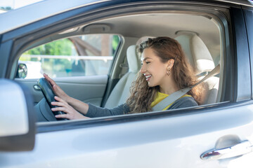 Young adult girl driving a new car