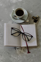 cup of coffee on the table with office items notebook, flashcard