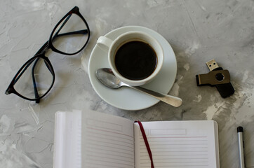 cup of coffee on the table with office items notebook, flashcard